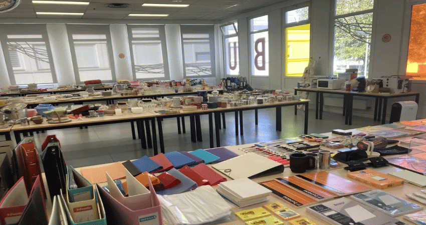 Photographie montrant tables avec fournitures scolaires et divers objets