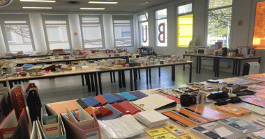 Photographie montrant tables avec fournitures scolaires et divers objets