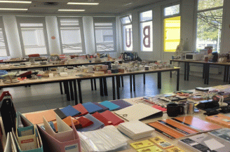 Photographie montrant tables avec fournitures scolaires et divers objets
